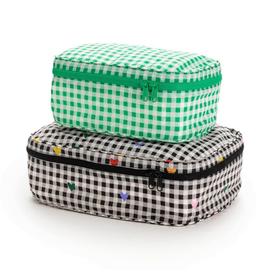 Baggu reusable recycled ripstop nylon packing cube set of 2, large is black and white gingham with colorful hearts and the small cube is green and white gingham print, stuffed and stacked.