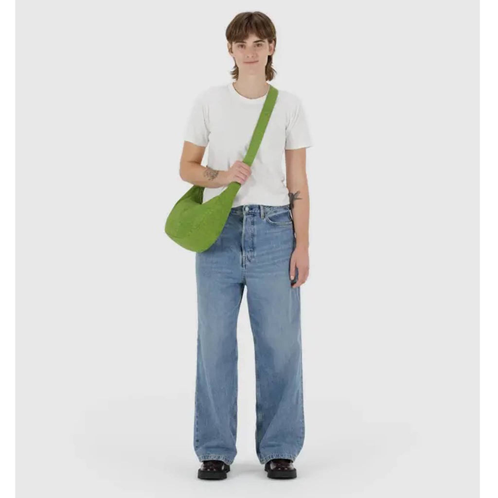 Baggu Medium Crescent Bag in Green Juice, with crossbody strap, on model.