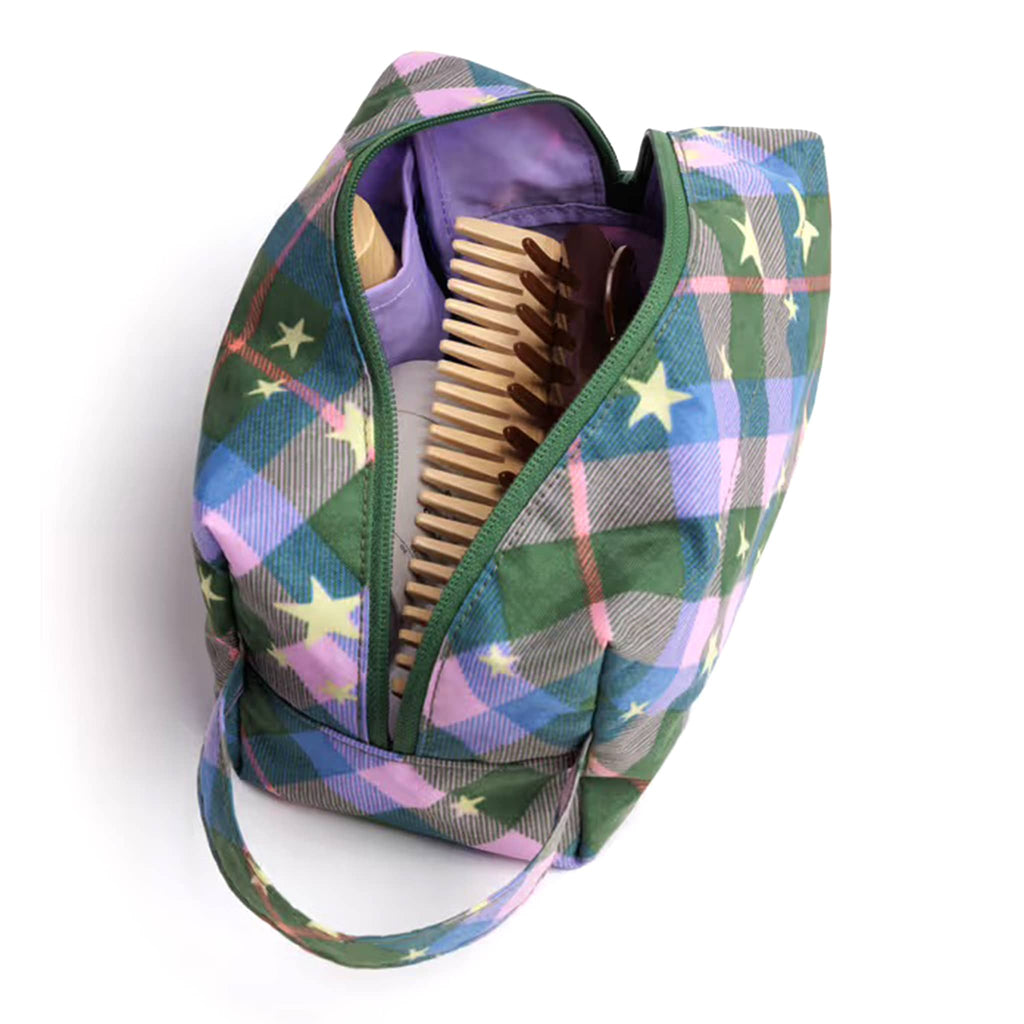 Baggu Green Star Plaid Dopp Kit, overhead view, unzipped with toiletries inside, on a white background.