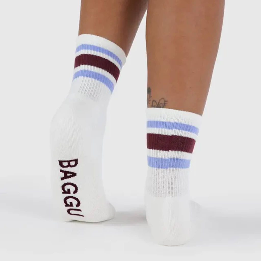 White socks with maroon and light purple stripes and 'BAGGU' branding on model's feet, on a white background.