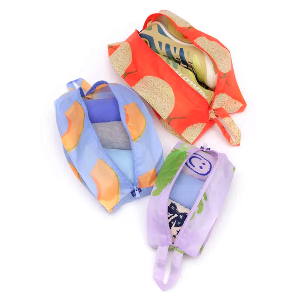 Baggu 3D zip set trio in Japanese Produce collection prints, open and filled with tees, socks and shoes.