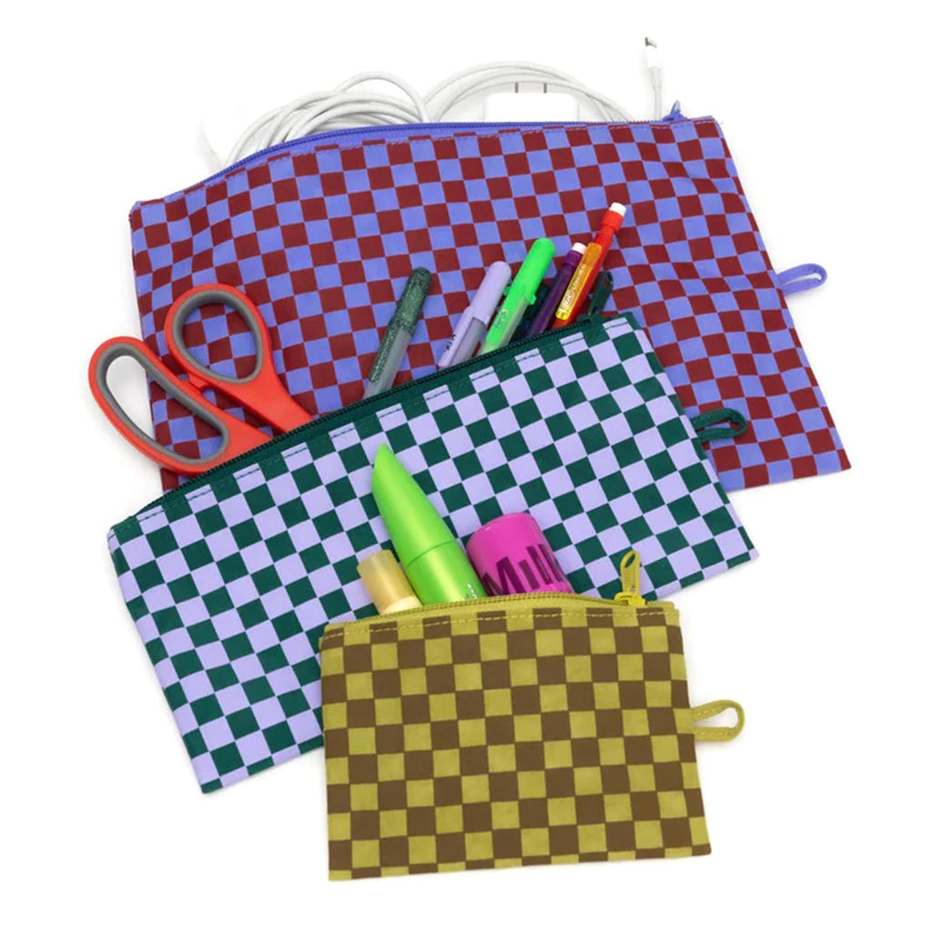 Baggu recycled ripstop nylon flat zipper pouches, set of 3 in assorted sizes with prints from the Jewel Checks collection, unzipped and filled with cosmetics, art supplies and charging cords.