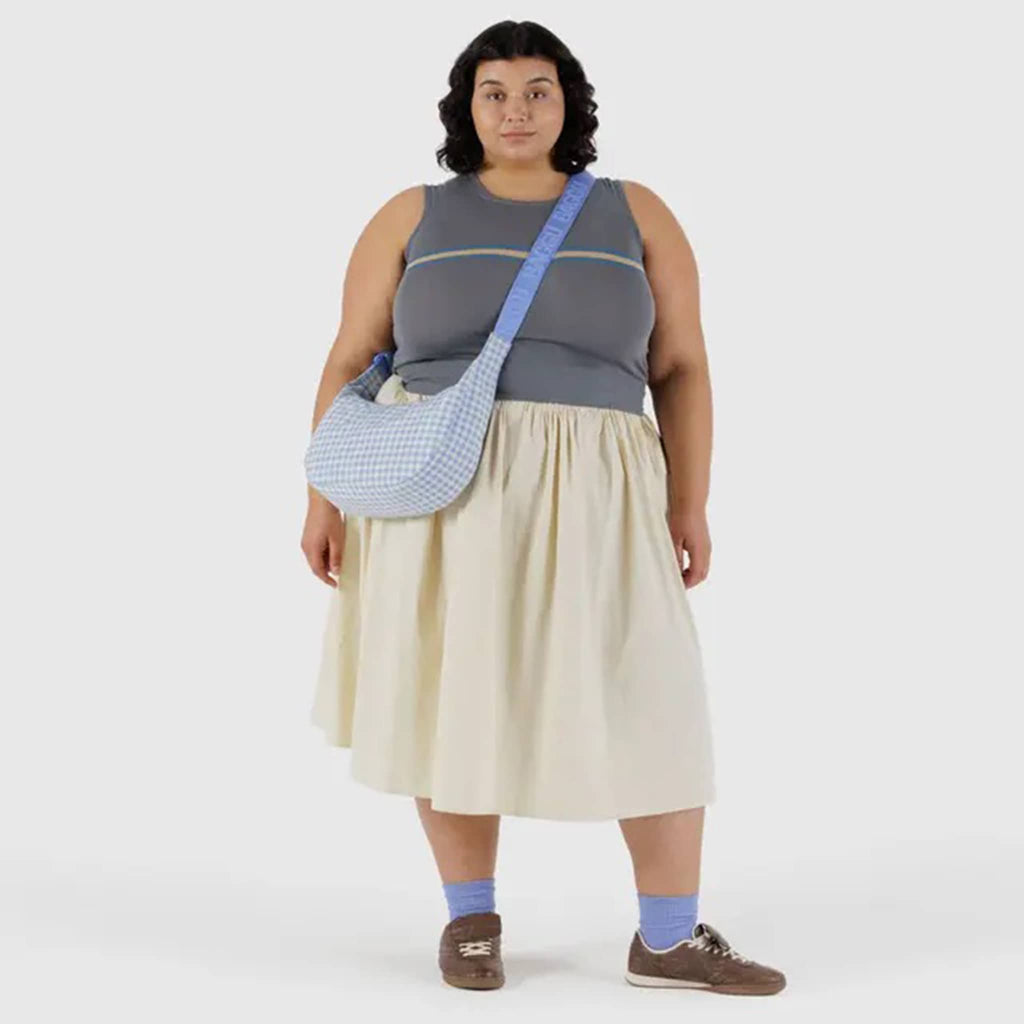 Baggu light blue gingham medium ripstop nylon crescent bag, on model.