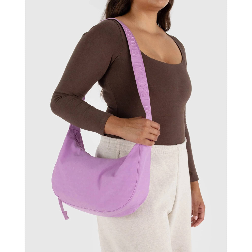 Baggu Medium Ripstop Nylon Crescent Bag in Peony with 47 inch adjustable tonal logo strap, on model's shoulder.