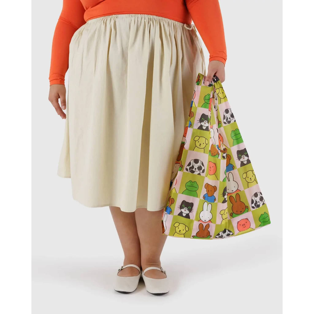 Standard Baggu in Miffy and Friends print, in model's hand.