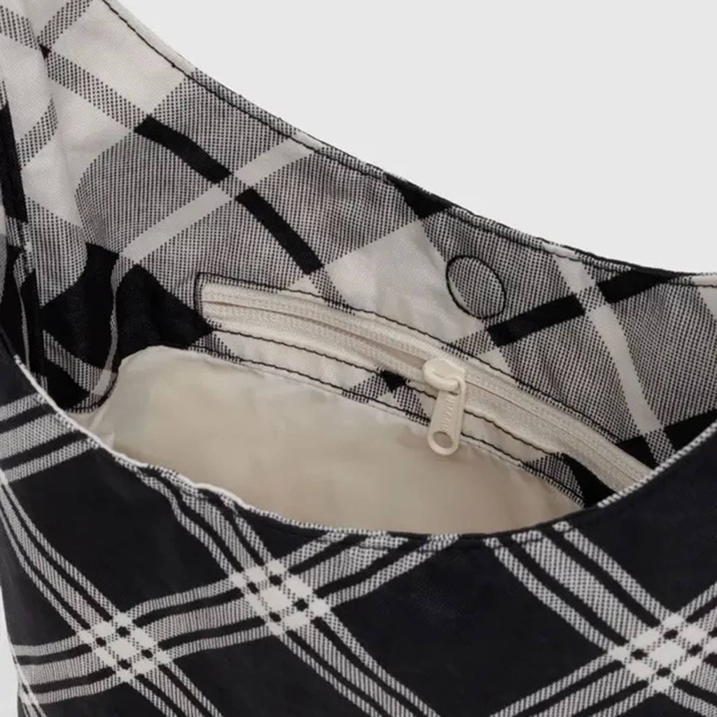 Black and white plaid bag, detail of magnetic closure and interior zip pocket.