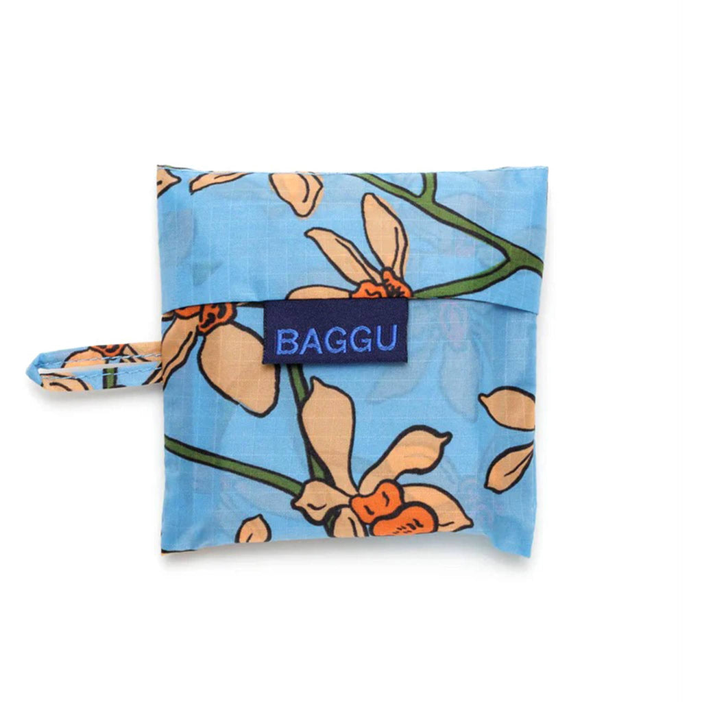 Baggu baby size eco-friendly recycled ripstop nylon reusable tote bag with the orange Orchid print on a medium blue background, in matching pouch.