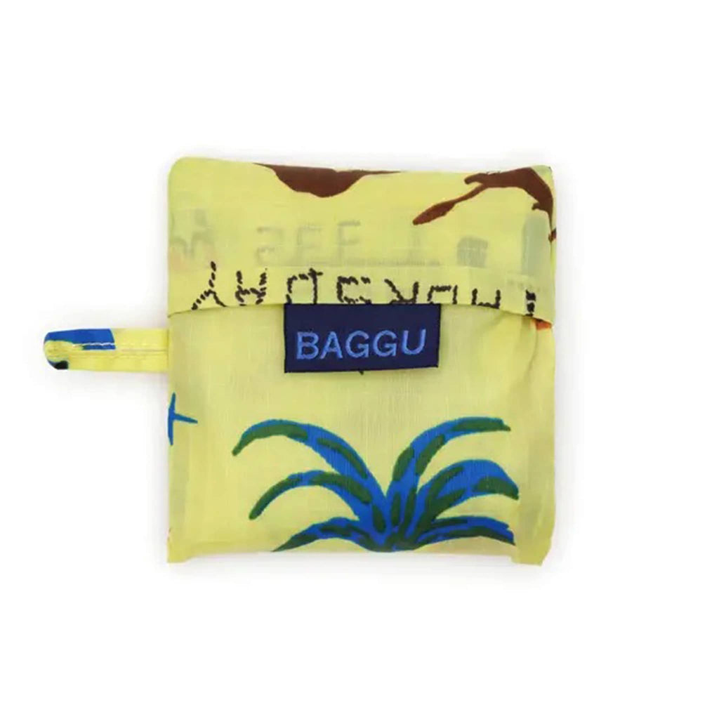 Folded yellow reusable bag in matching pouch with 'BAGGU' logo on a white background.