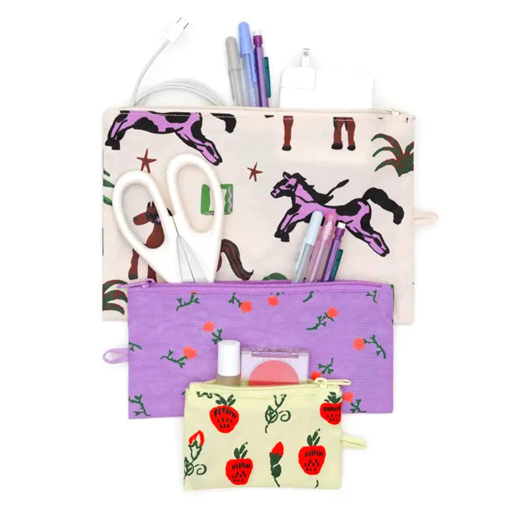 Baggu Painted Prairie recycled heavyweight nylon flat zipper pouch, set of 3 in different prints, open with cosmetics, pens, scissors and a charger.