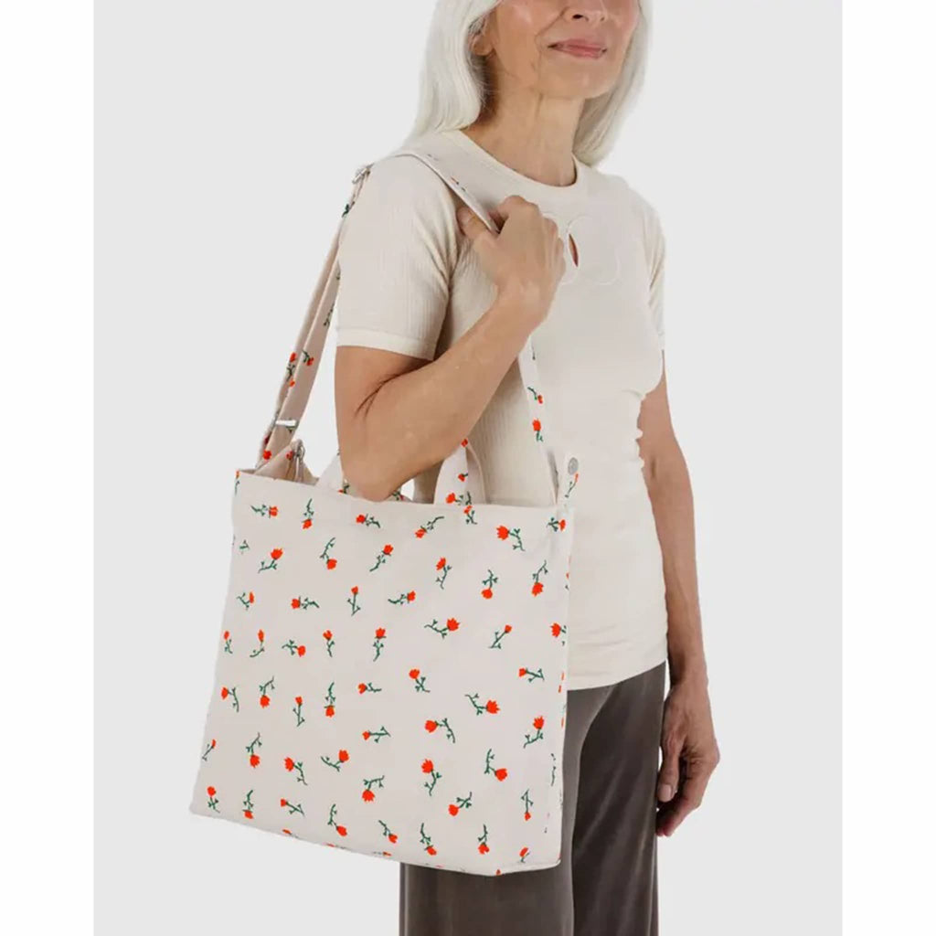 Woman holding a Baggu Painted Wildflower Horizontal Zip Canvas Duck Bag.