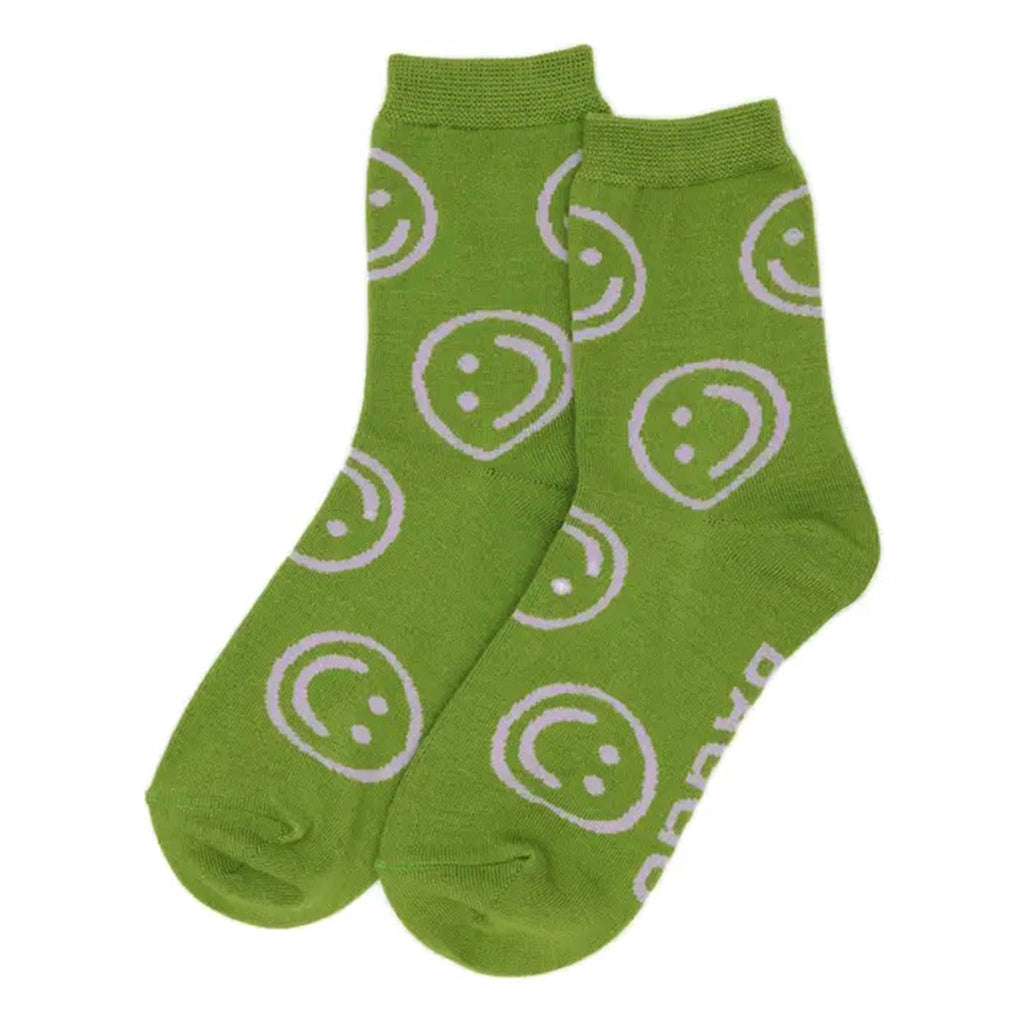 Pear green crew socks with lilac smiley face patterns on a white background.