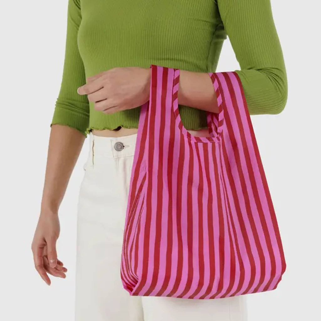 Baby Baggu Pink and Red Painted Stripe ripstop nylon reusable bag, on models arm.