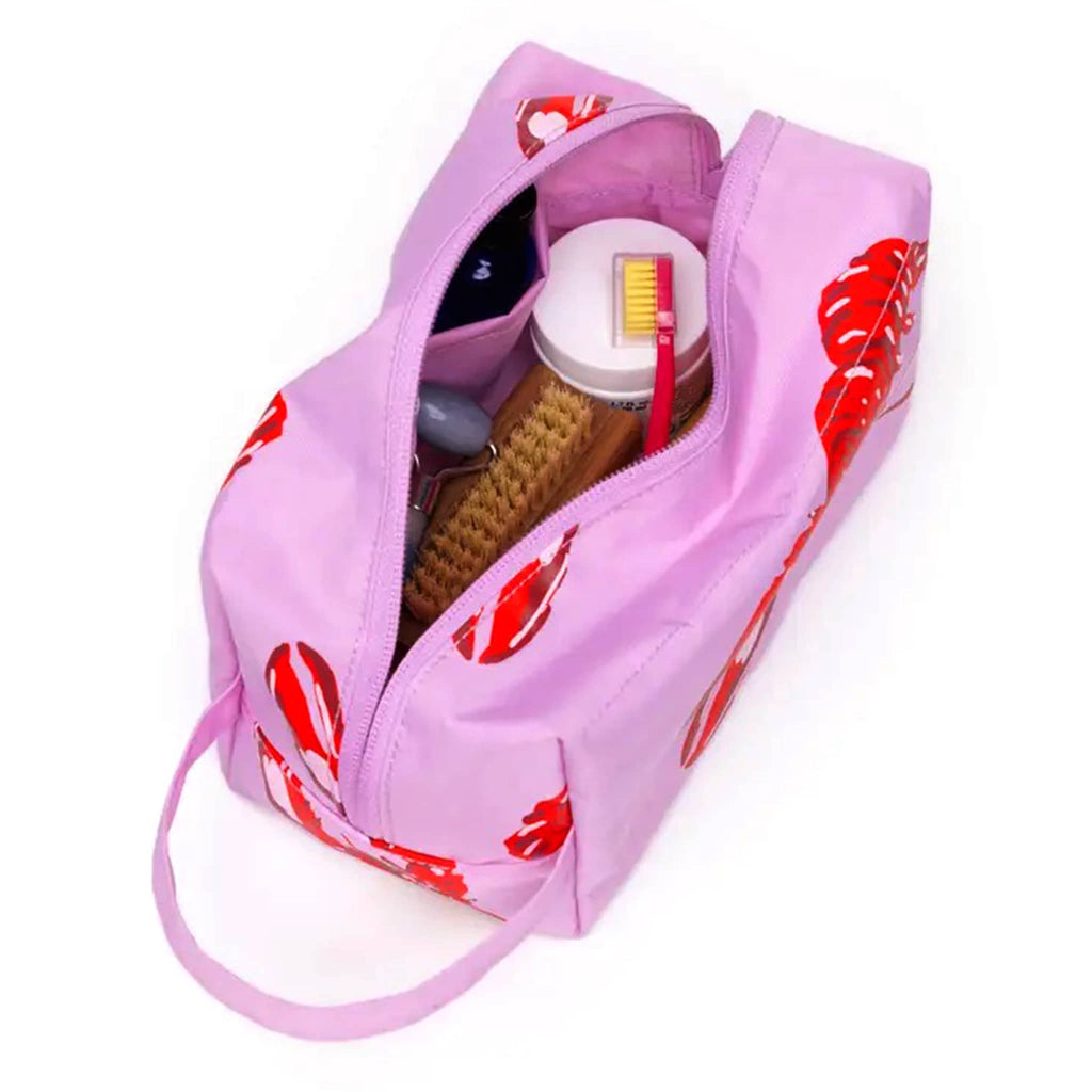 Baggu Pink Lobster Dopp Kit, open showing toiletries inside.
