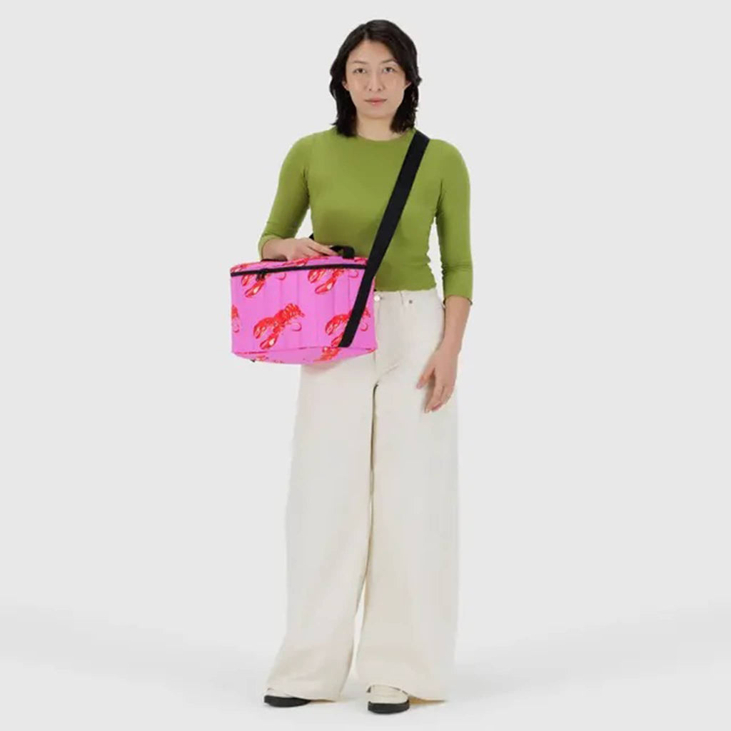 Baggu Pink Lobster insulated puffy cooler bag, on models shoulder.