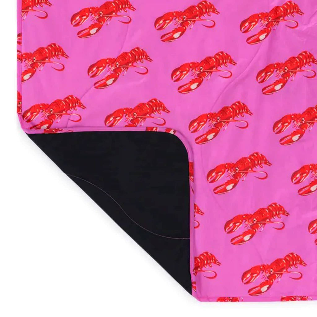 Baggu Pink Lobster puffy recycled ripstop nylon and polyester picnic blanket, corner rolled back.