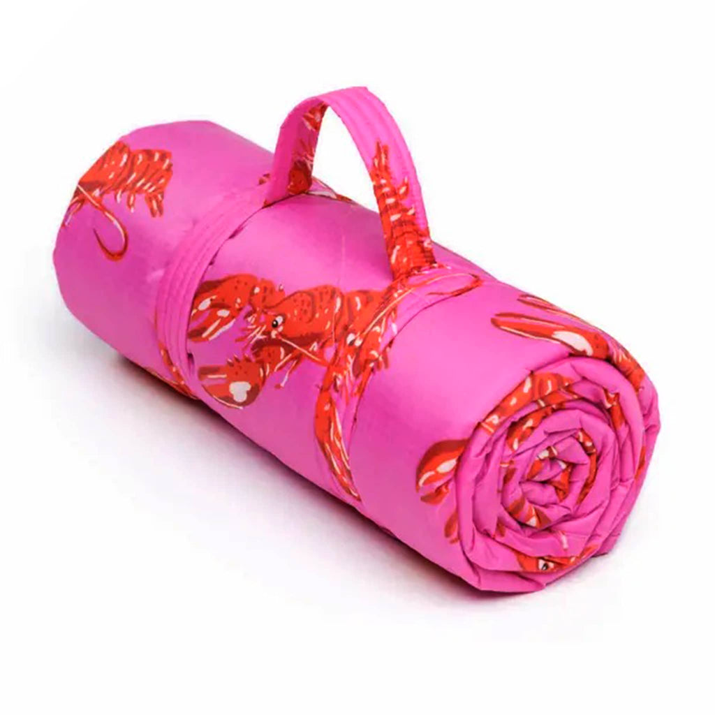 Baggu Pink Lobster puffy recycled ripstop nylon and polyester picnic blanket rolled up.