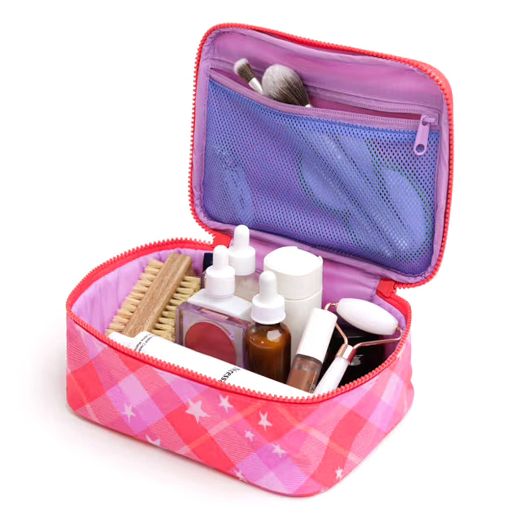 Pink plaid makeup bag with cosmetic items on a white background.
