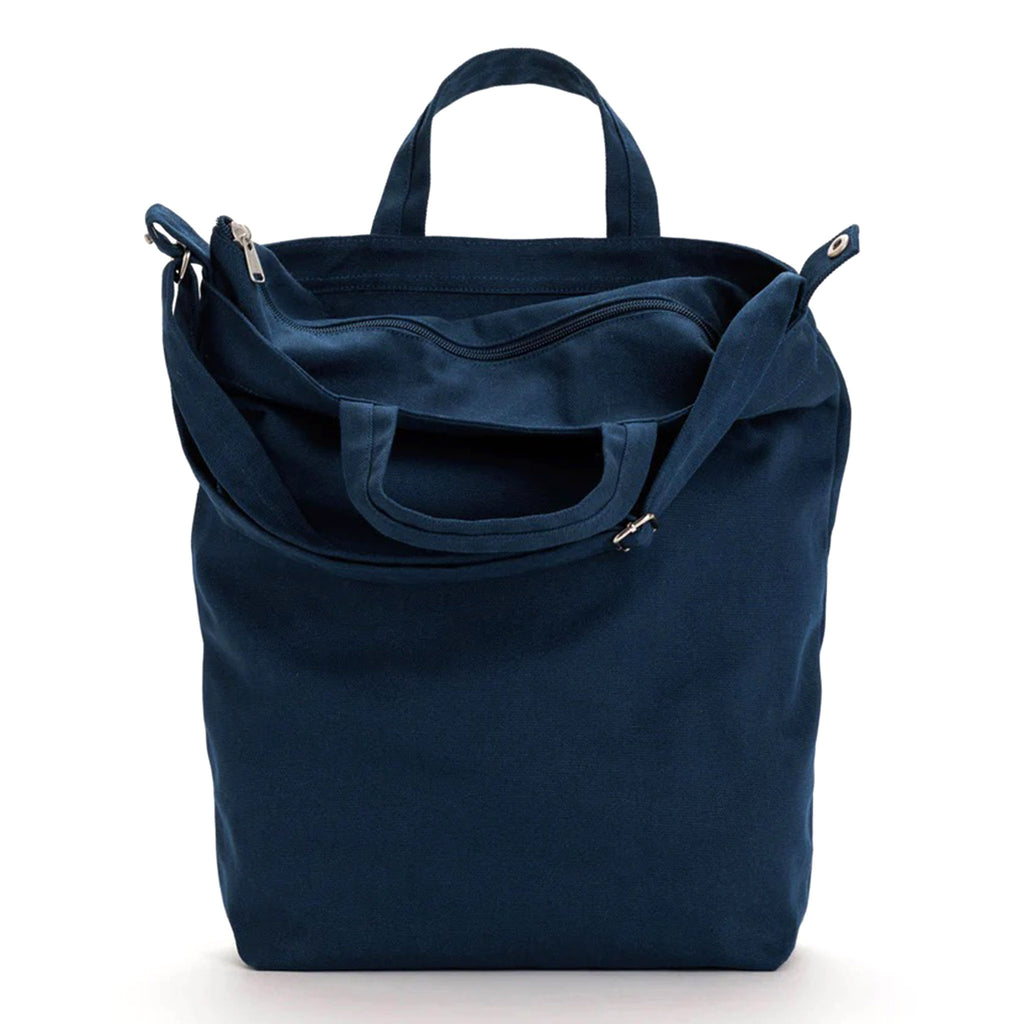 Baggu recycled cotton canvas duck bag tote with zip top closure in navy blue, front view with top bent down to show zipper.