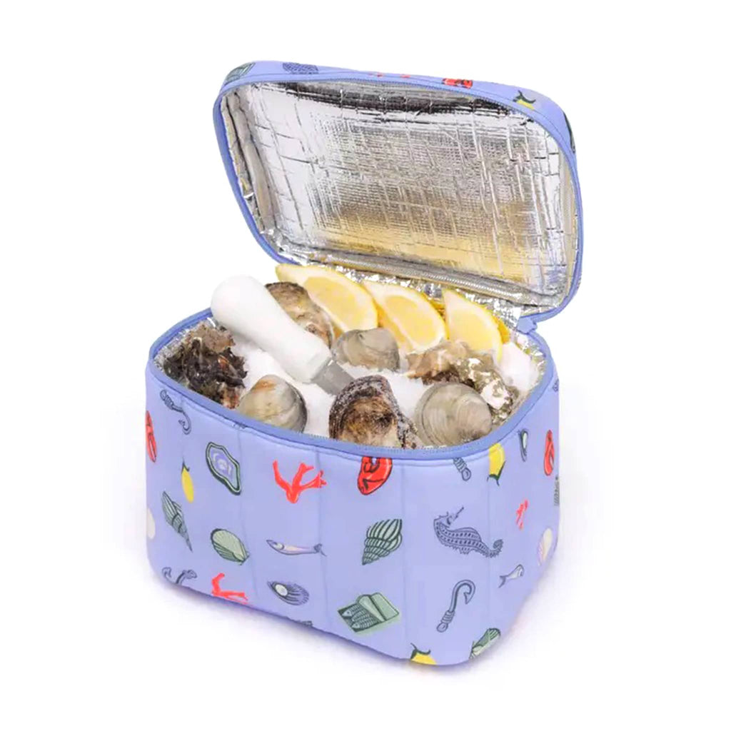 Baggu Insulated Puffy Nylon Lunch Bag with Sea Charms print, front angle view, lid open with oysters and lemons and ice inside.