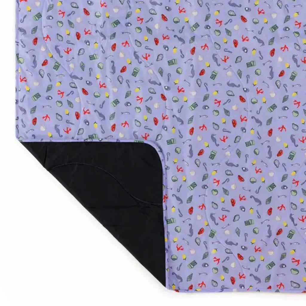 Baggu Sea Charms puffy recycled ripstop nylon and polyester picnic blanket, corner rolled back.