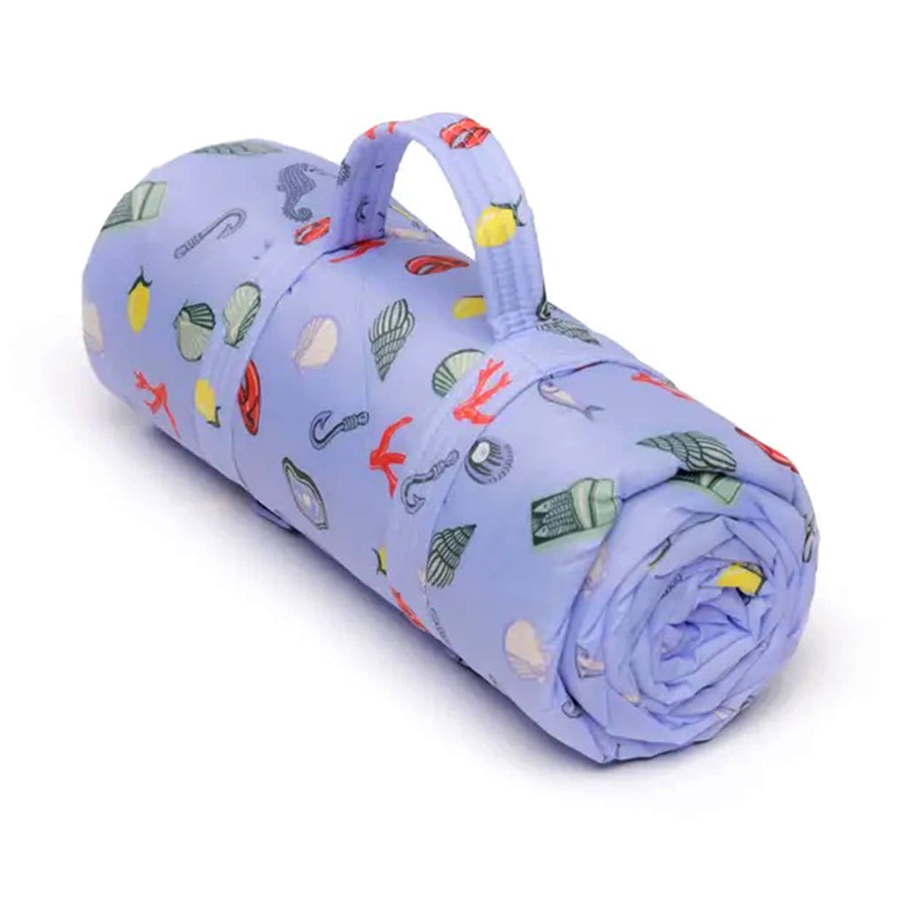 Baggu Sea Charms puffy recycled ripstop nylon and polyester picnic blanket rolled up.