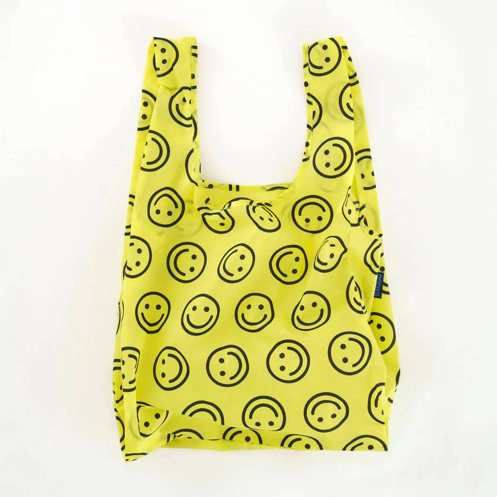 Bright yellow Baggu standard bag with repeating black smiley faces.