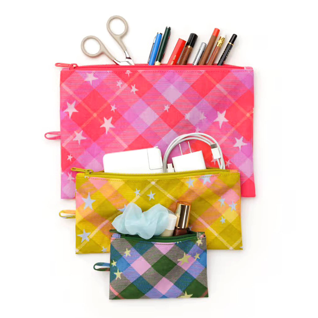 Set of colorful plaid pouches with stationery items on a white background.