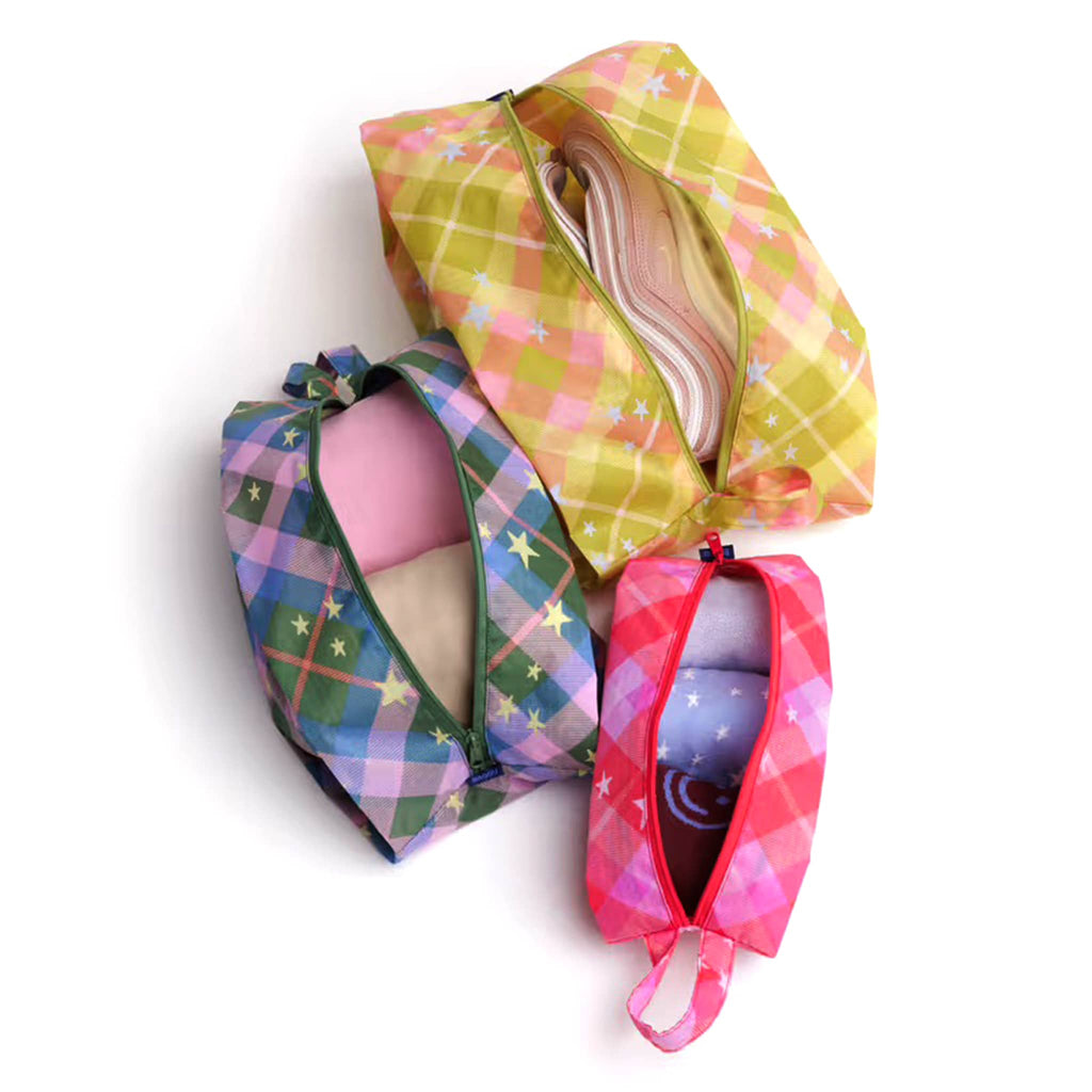 Baggu 3D Zip Bags in Star Plaid prints, overhead view, unzipped with shoes and clothing inside, on a white background.
