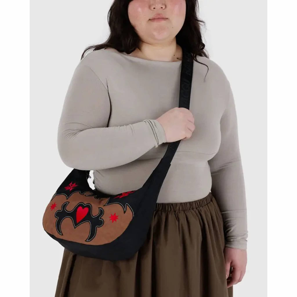 Person holding the Baggu Western Applique medium ripstop nylon crescent bag.