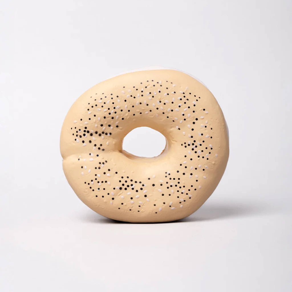 Bagel shaped fidget toy with speckled top standing up, front view on a light gray background.