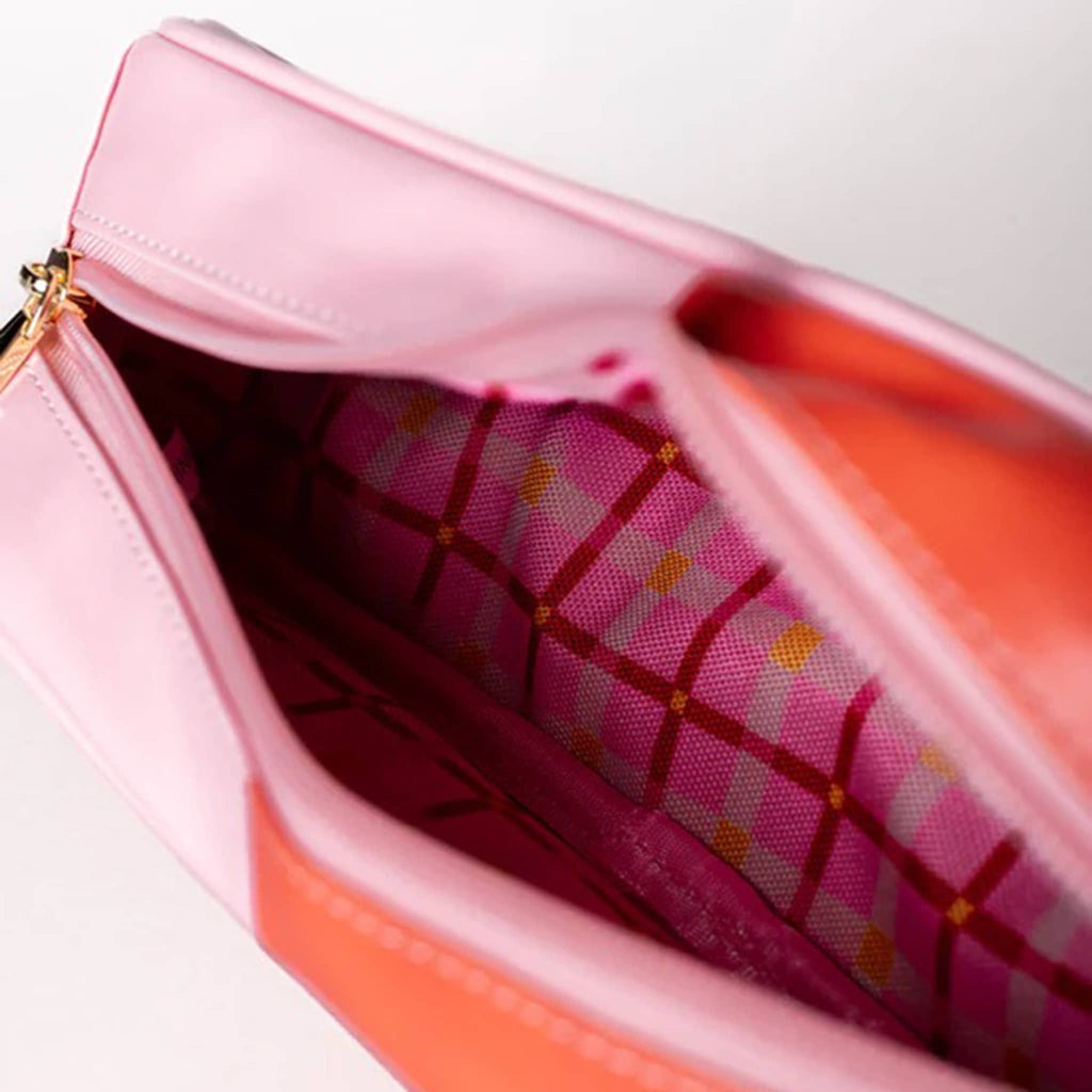 Close-up of a pink handbag with a patterned interior.