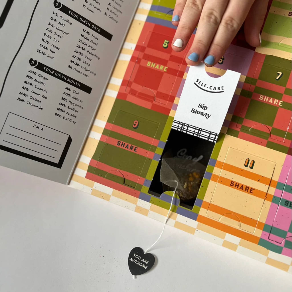 'It's Nice to Be Nice' sampler gift box from Big Heart Teas, interior view with tea bag coming out of numbered window.