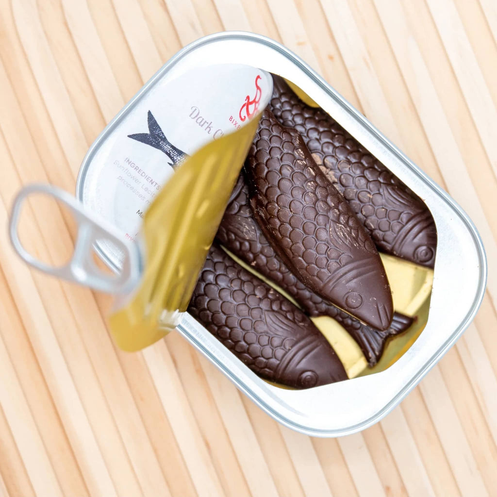 Bixby Dark Chocolate Sardines in vintage-style tin, lid peeled back showing chocolate fish.