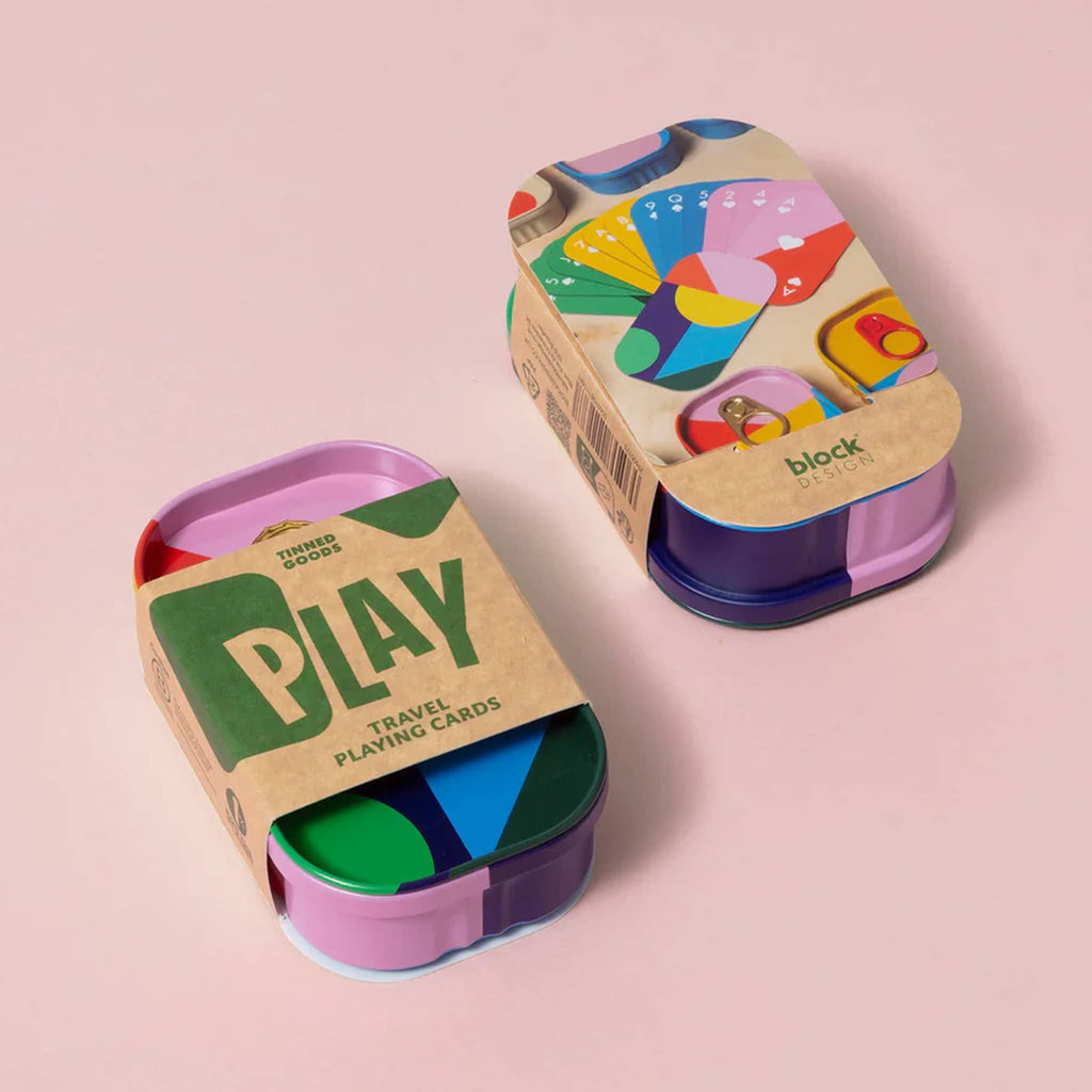 Colorful tin packaging for playing cards with belly band packaging, top and bottom shown on a pink background.