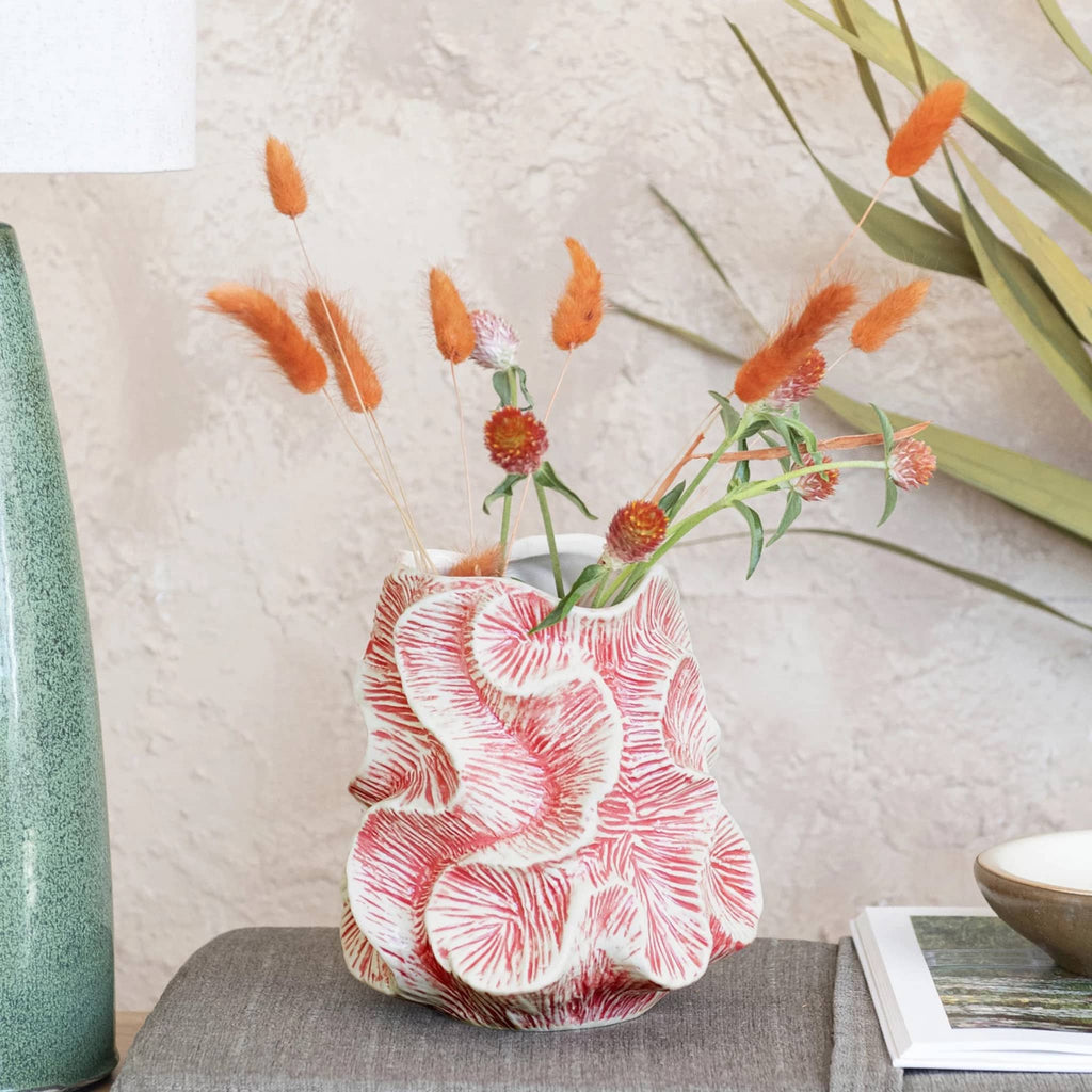 Bloomingville pink and white textured stoneware organic-shaped vase with flowers in a room setting.