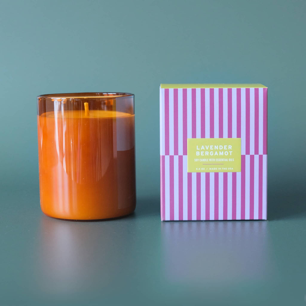 Botanica Essentials 8 ounce Lavender and bergamot scented soy candle with essential oils in amber glass vessel with striped box packaging.