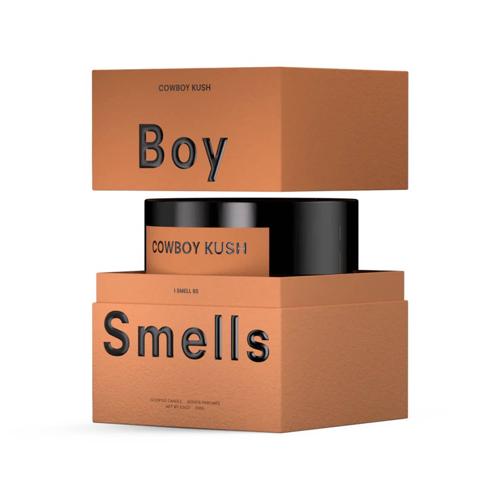Boy Smells Cowboy Kush scented 9 ounce Classics candle in black glass vessel with dark orange label, in open box.
