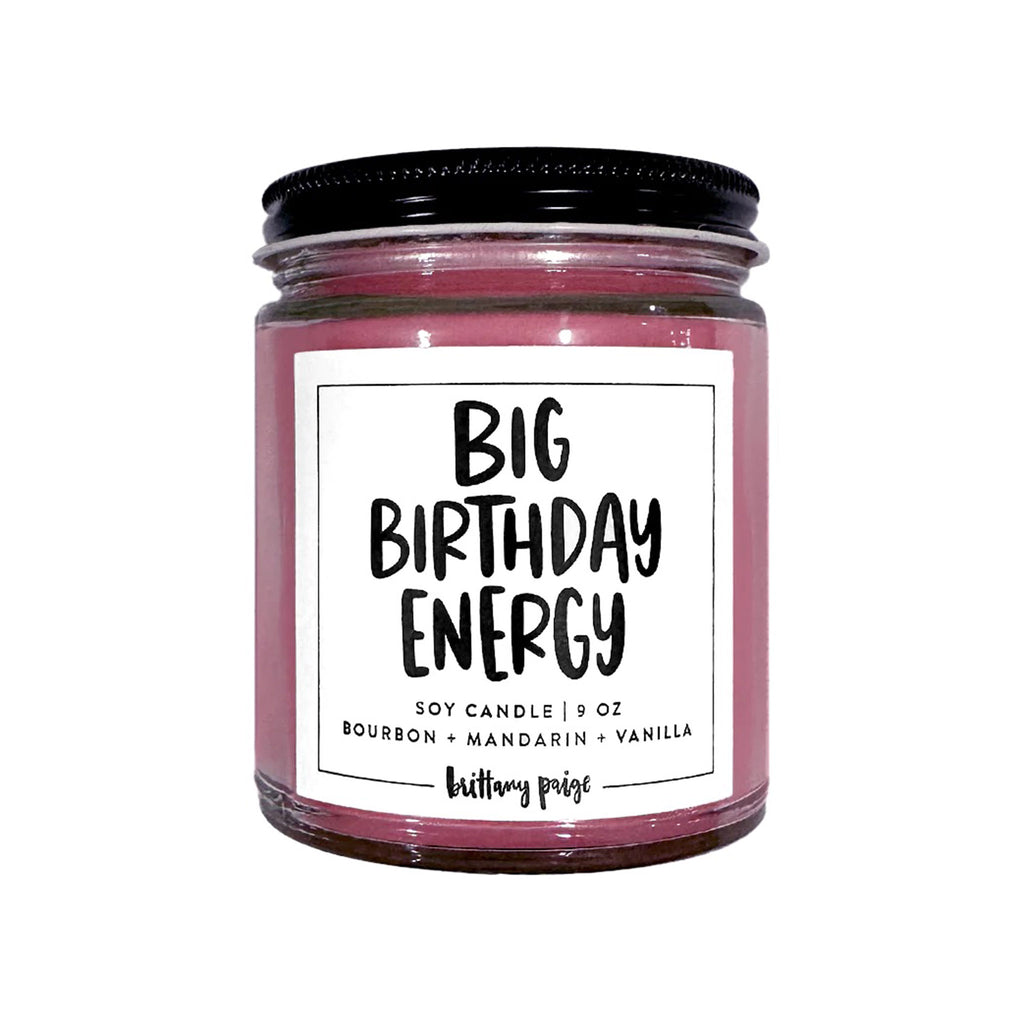 Brittany Paige Big Birthday Energy Bourbon, Mandarin, Vanilla scented soy wax candle in clear glass jar with a black lid and white label.