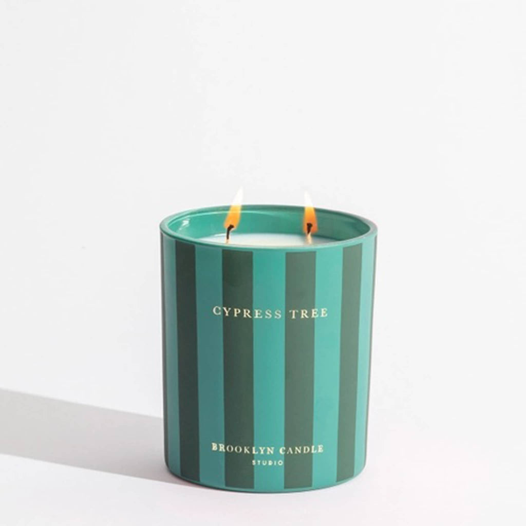 Striped candle with 'Cypress Tree' and 'Brooklyn Candle Studio' text on a white background.