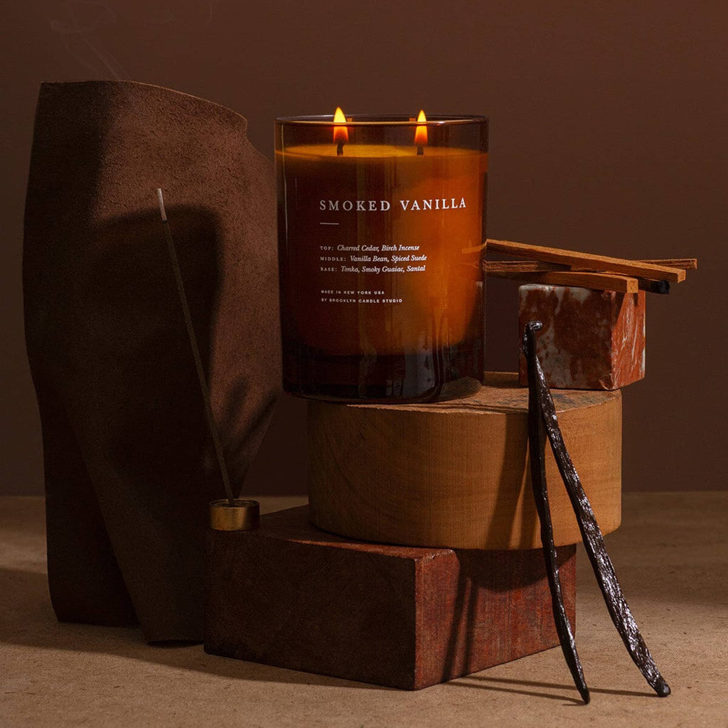 Smoked Vanilla candle on a wooden stand with a dark background.