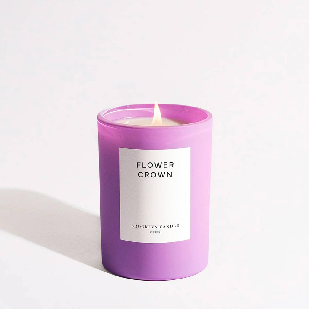 Brooklyn Candle Studio Flower Crown scented candle in matte lilac glass vessel with white label and lit wick.