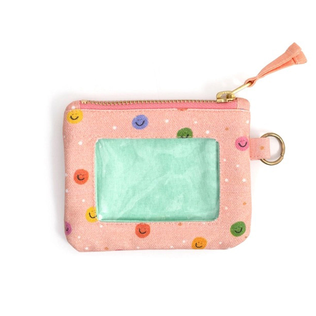 Callie Danielle Happy Day Smiley Canvas ID Wallet, peach fabric has rainbow dots with smiley faces, front view with clear window, gold tone top zip and peach zip pull.