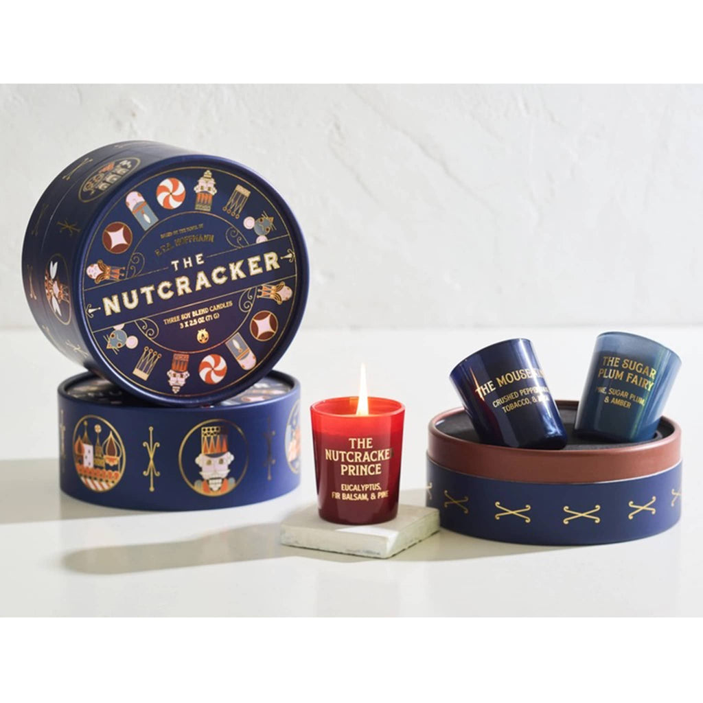 Decorative votive candles and tin packaging with 'The Nutcracker' theme on a white background.