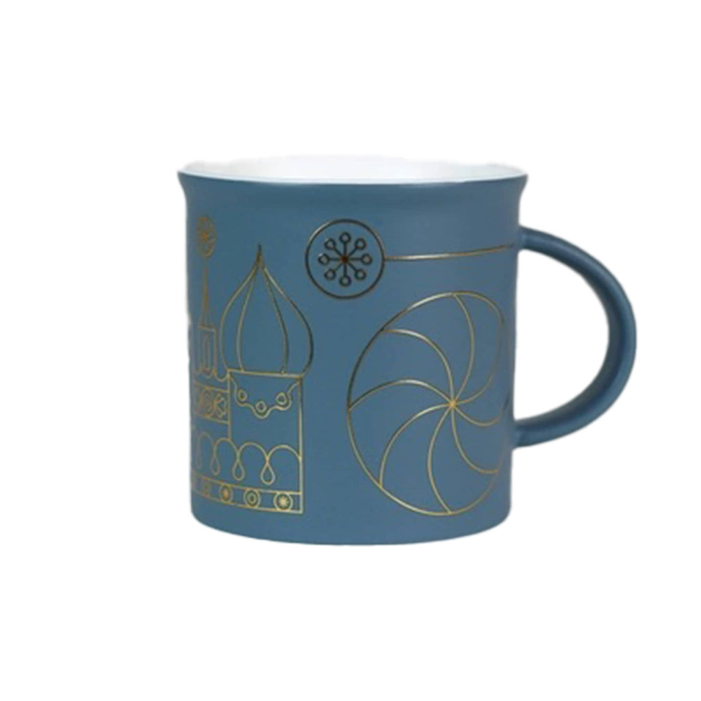 Blue mug with gold sugar plum fairy designs on a white background.
