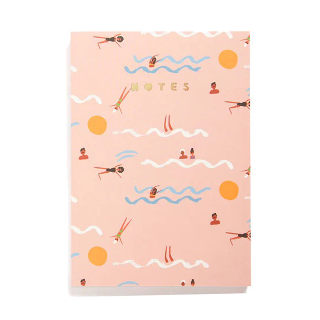 Large Notebook from Carolyn Suzuki with illustrations of swimmers with white and blue waves and orange suns on the cover and blank pages inside.