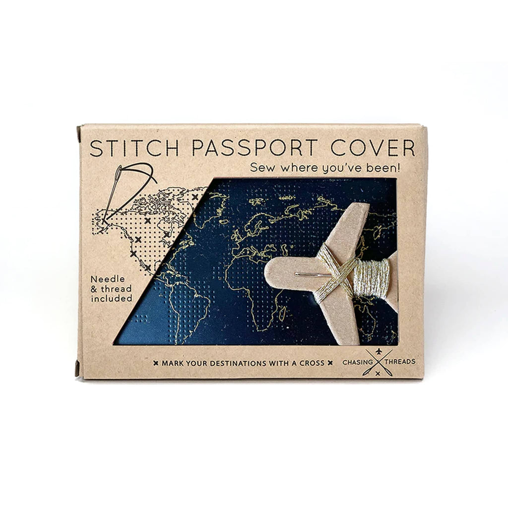 Chasing Threads Black faux leather stitch passport cover with needle and gold thread in kraft box packaging, front view.