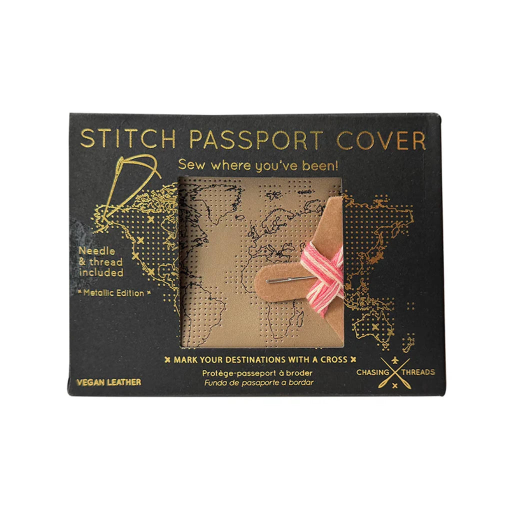 Chasing Threads gold faux leather stitch passport cover with needle and pink thread in kraft box packaging, front view.