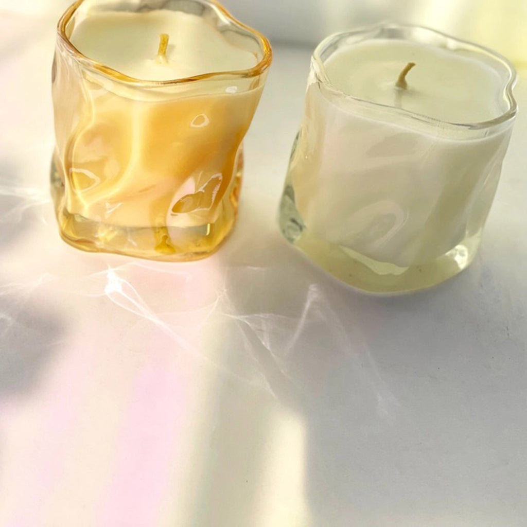 Choice Blooms scented candles made from a hemp, coconut and soy wax blend, in a curvy clear and a curvy amber glass vessel, both with hemp wick.