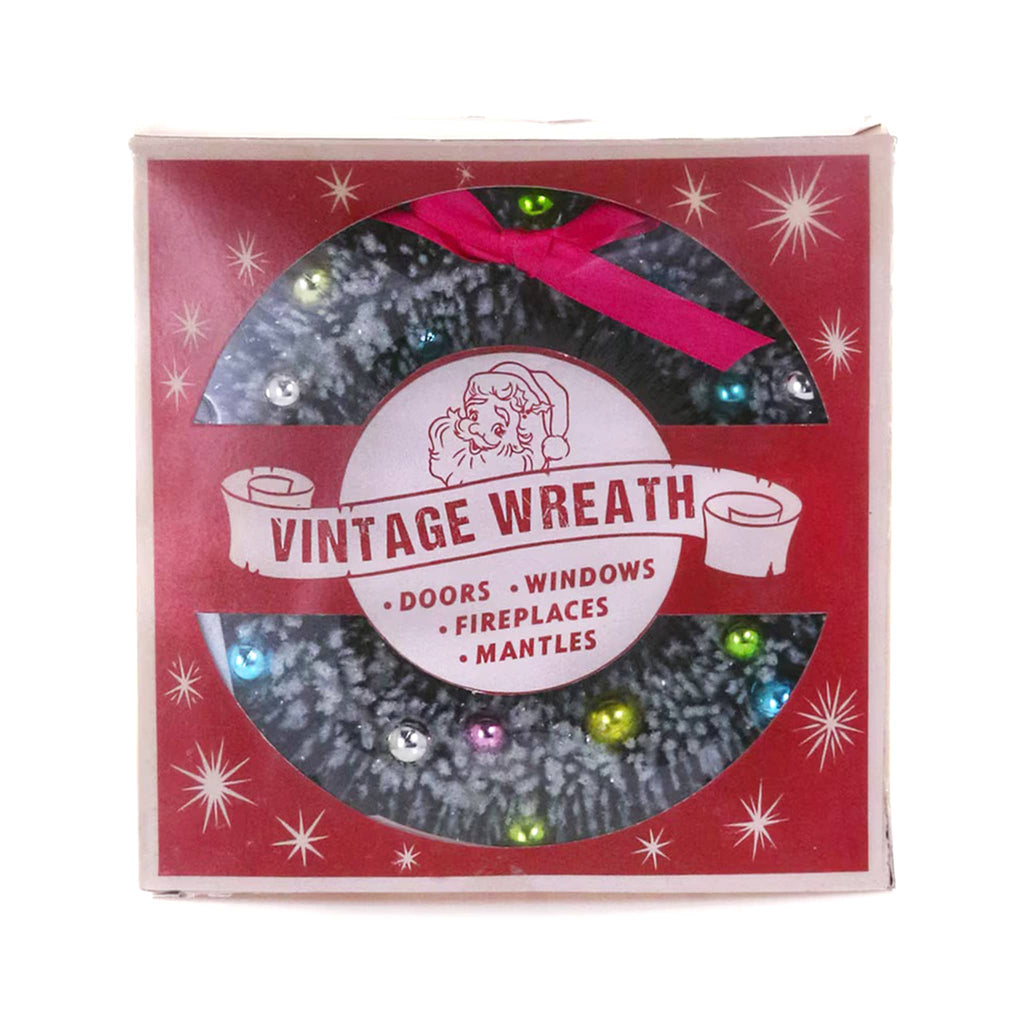 Vintage-style wreath packaging with a red background and festive design.