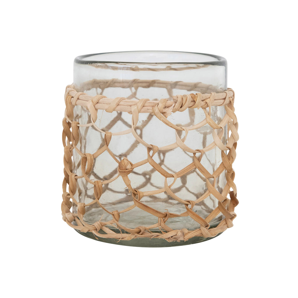 Creative Co-op woven rattan sleeve around a clear round glass votive holder.